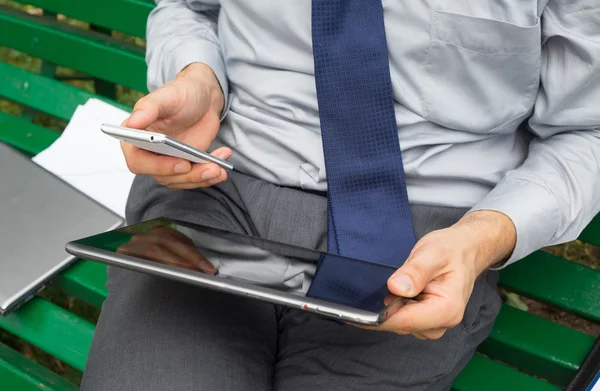 Businessman holding mobile phone and tablet — Stock Photo, Image