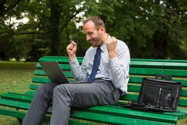 Glada affärsman med laptop — Stockfoto