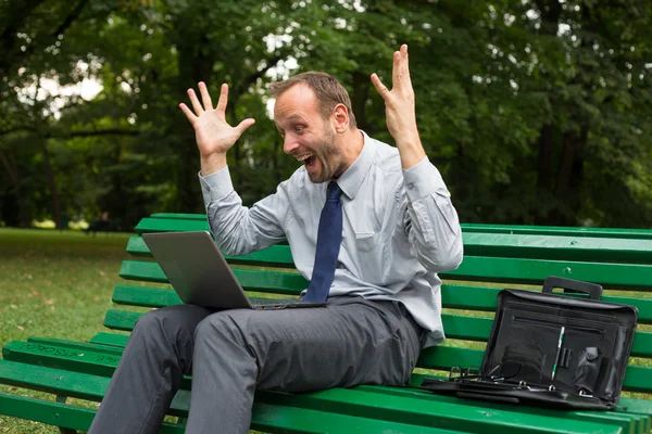 Opgewonden zakenman met laptop — Stockfoto