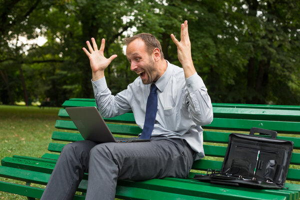 Excited businessman with laptop