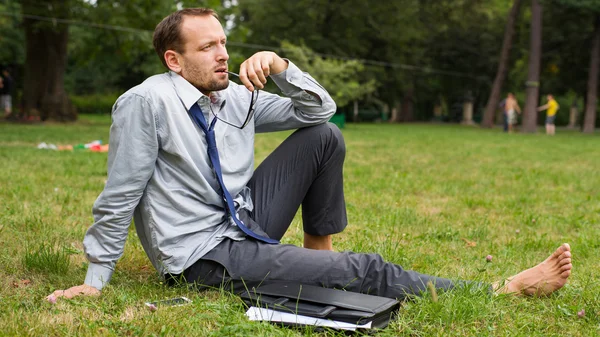 Ensive businessman on grass — Stock Photo, Image