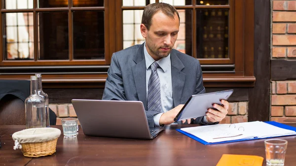 Homem de negócios com laptop e tablet — Fotografia de Stock