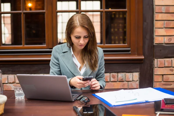 Kobieta interesu laptop i telefon komórkowy — Zdjęcie stockowe