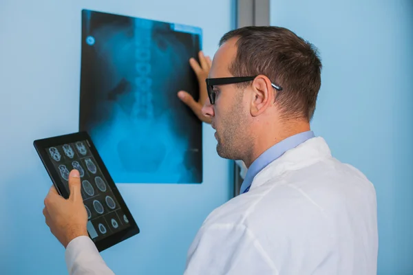 Доктор с планшетом и рентгеновским снимком — стоковое фото