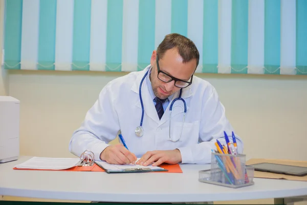 Doctor sitting behind desk — Stock Photo, Image