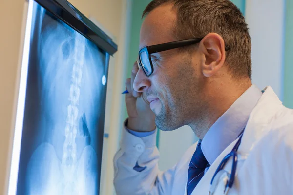 Arzt schaut sich Röntgenbild an — Stockfoto