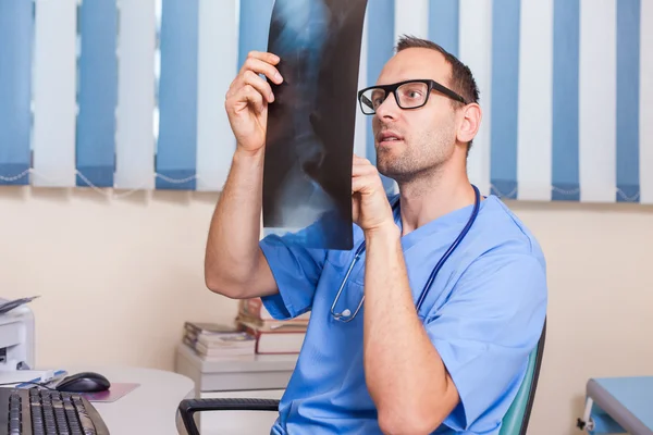 Läkaren tittar på röntgen bild — Stockfoto