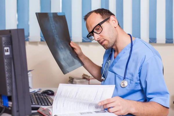 Arzt schaut sich Röntgenbild an — Stockfoto