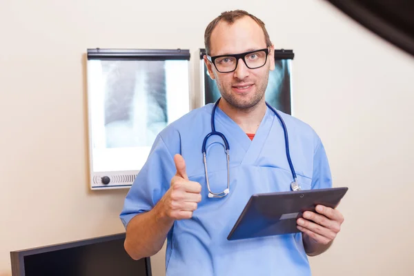 Médico com comprimido mostrando polegar para cima — Fotografia de Stock