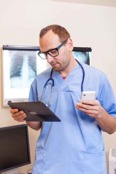 Medico con tablet e telefono cellulare — Foto Stock