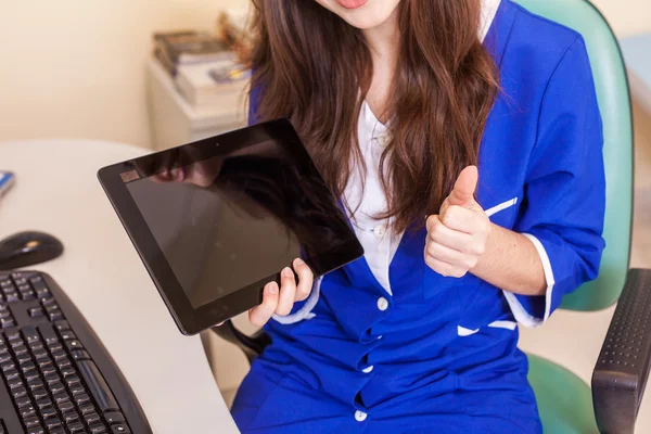 Médico femenino usando tableta y mostrando el pulgar hacia arriba —  Fotos de Stock