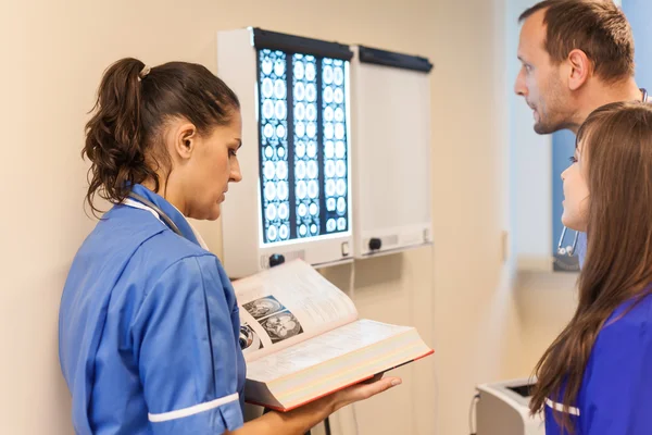 Doctors examining x-ray images — Stock Photo, Image