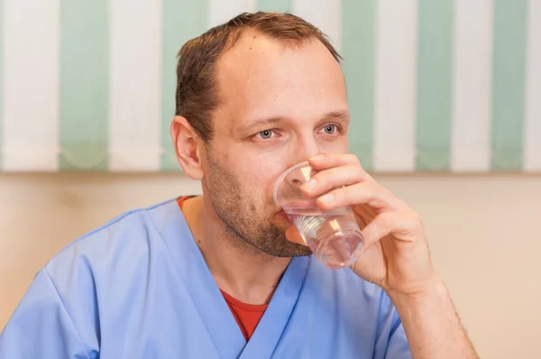 Doctor drinking water — Stock Photo, Image