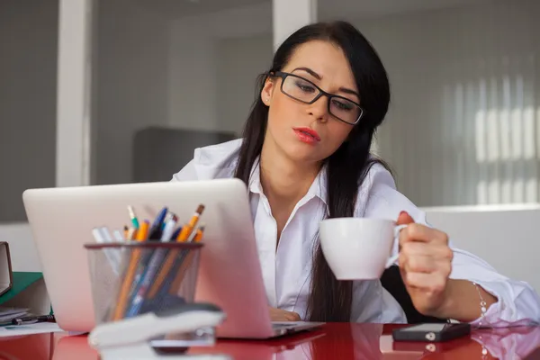 Affärskvinna som sitter vid skrivbord — Stockfoto