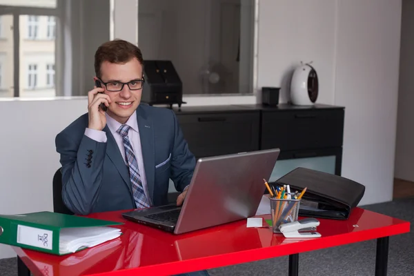 Hombre de negocios con portátil y teléfono móvil —  Fotos de Stock