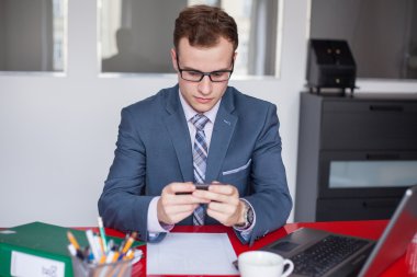 Dizüstü bilgisayarı ve cep telefonu olan iş adamı