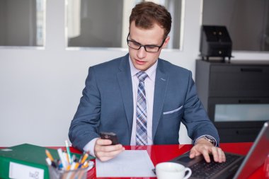 Dizüstü bilgisayarı ve cep telefonu olan iş adamı