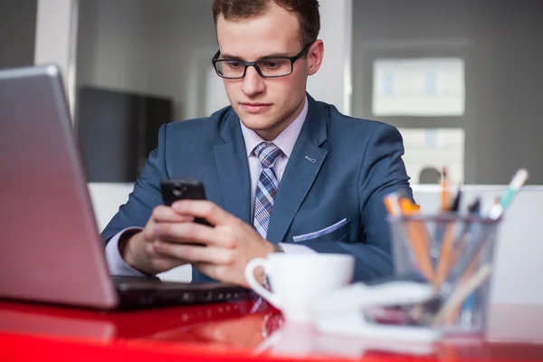 Hombre de negocios con portátil y teléfono móvil —  Fotos de Stock