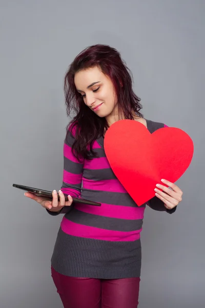 Mujer sosteniendo corazón y tableta — Foto de Stock