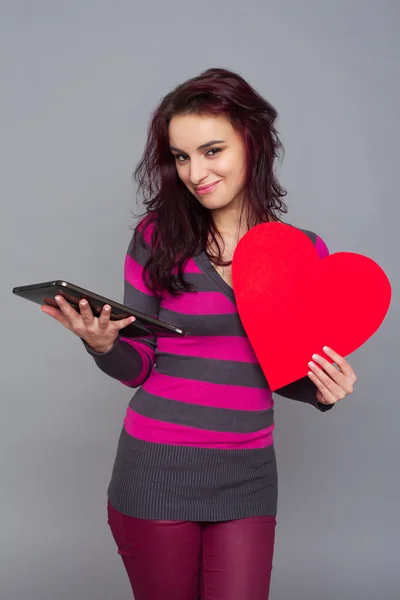Woman holding heart and tablet — Stock Photo, Image