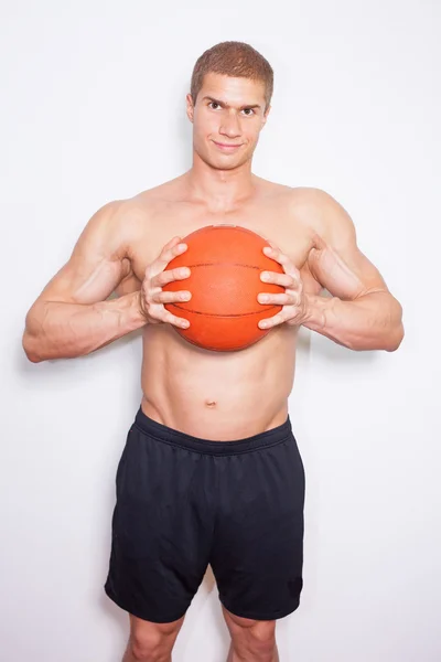 Muscular man holding ball — Stock Photo, Image