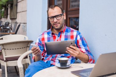 Tablet ve cep telefonu kullanan adam