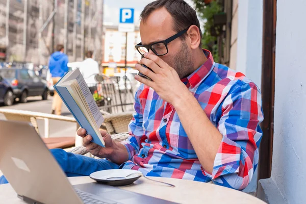 Hombre leyendo libro y bebiendo café — Foto de Stock