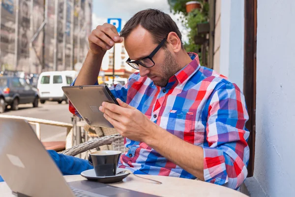 Man using tablet and drinking coffee — Stock Photo, Image