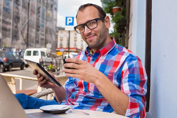 Man using tablet and drinking coffee — Stock Photo, Image