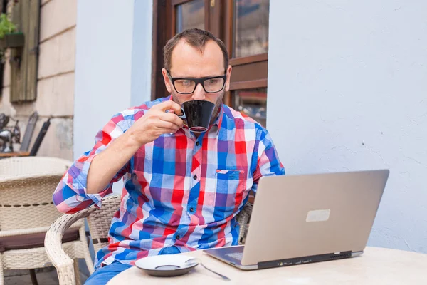 Hombre con portátil y café — Foto de Stock