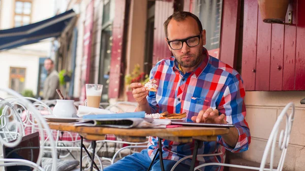 Man eating and using tablet — Stock Photo, Image