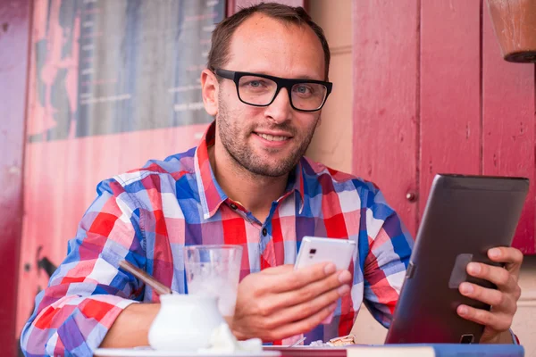 Muž pomocí tabletu a mobilní telefon — Stock fotografie