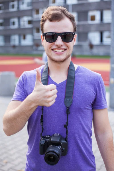Homem segurando câmera e mostrando sinal ok — Fotografia de Stock