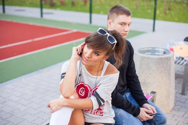 Jongen en meisje met behulp van mobiele telefoons — Stockfoto