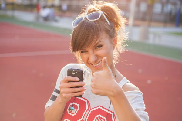 Mädchen mit Handy zeigt Daumen hoch — Stockfoto