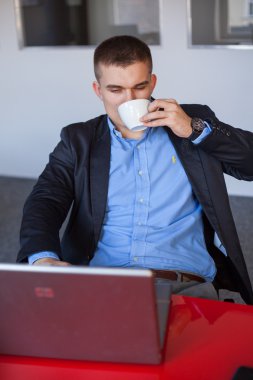 dizüstü bilgisayar kullanan ve kahve içmek işadamı