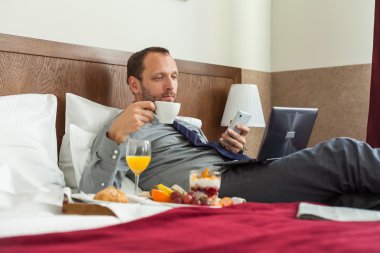 Kahvaltı sırasında telefon kullanarak iş adamı