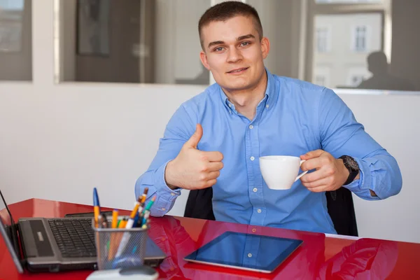 Empresario sosteniendo taza y mostrando el pulgar hacia arriba —  Fotos de Stock