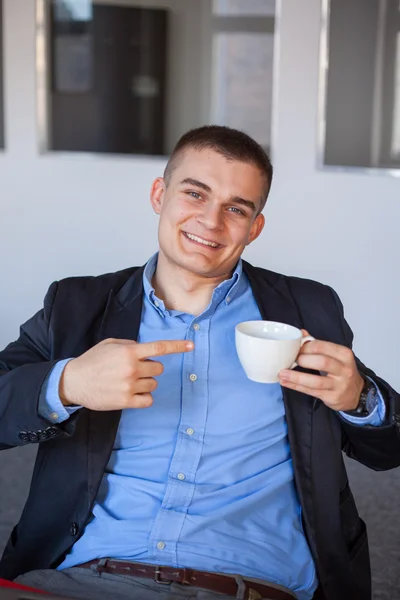 Businessman pointing at coffee — Stock Photo, Image