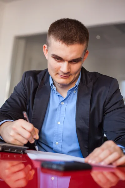 Uśmiechający się biznesmen podpisywania dokumentów — Zdjęcie stockowe