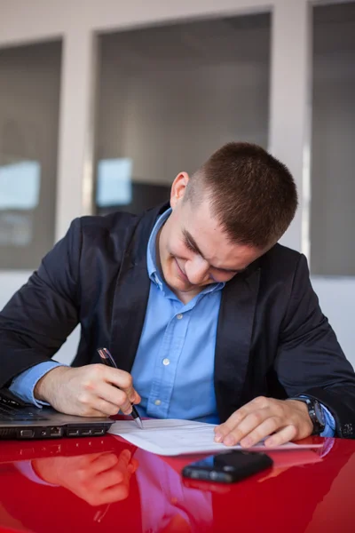 Lächelnder Geschäftsmann beim Unterschreiben von Dokumenten — Stockfoto