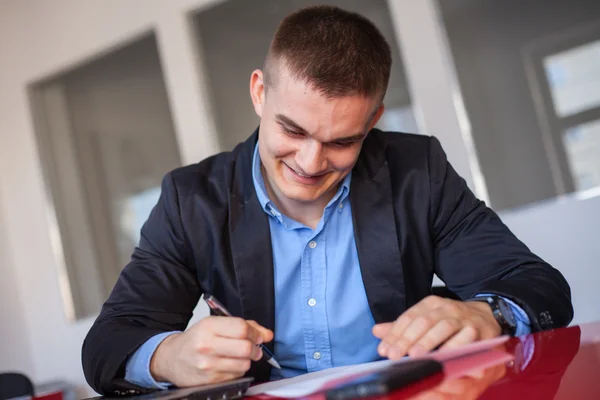 Lächelnder Geschäftsmann beim Unterschreiben von Dokumenten — Stockfoto