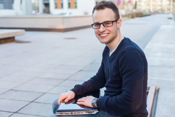 Dizüstü bilgisayar ile gülümseyen adam — Stok fotoğraf
