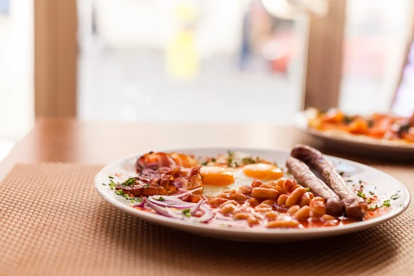 Ovos fritos, enchidos, feijões e bacon — Fotografia de Stock