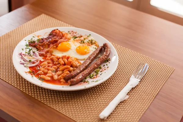 Ovos fritos, enchidos, feijões e bacon — Fotografia de Stock