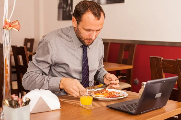 Businessman eats in restaurant — Stock Photo, Image