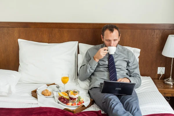 Affärsman med laptop under frukosten — Stockfoto