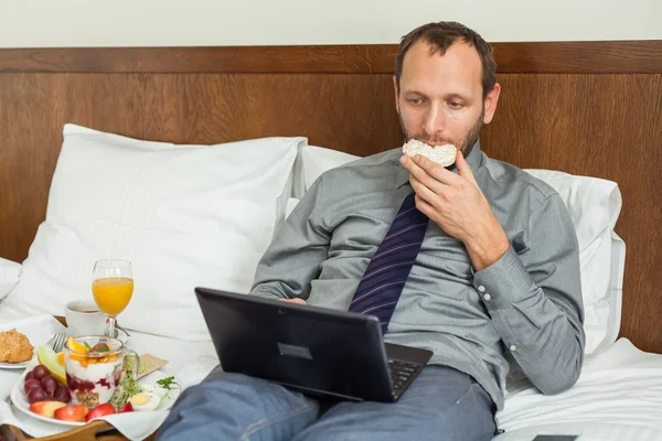 Empresário usando laptop durante o café da manhã — Fotografia de Stock