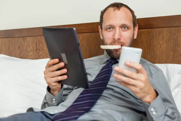 Бизнесмен с помощью телефона и планшета во время завтрака — стоковое фото