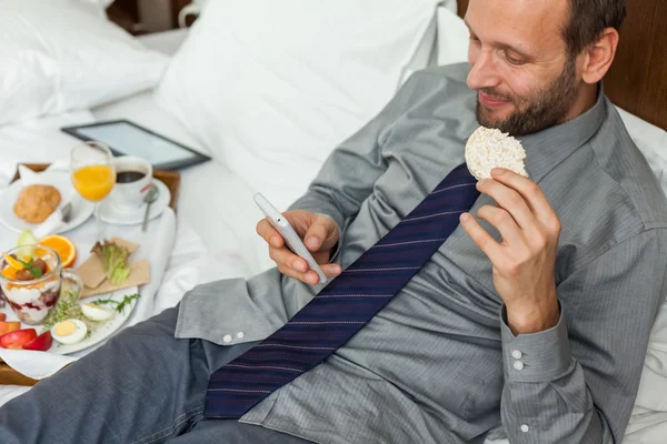 Kahvaltı sırasında telefon kullanarak iş adamı